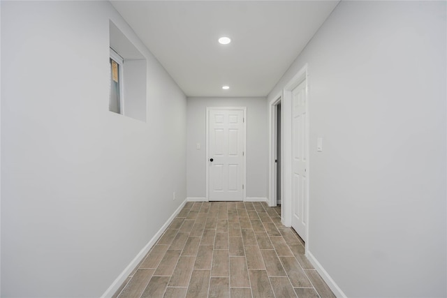 corridor with wood finished floors, recessed lighting, and baseboards