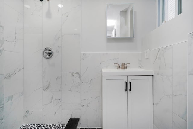 bathroom featuring vanity, tile walls, and a tile shower