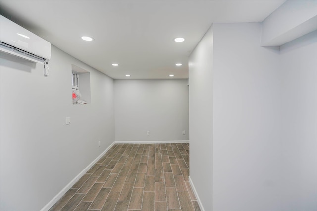 finished basement with recessed lighting, baseboards, an AC wall unit, and wood finished floors