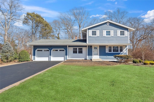 view of front of home featuring a front lawn, an attached garage, and driveway