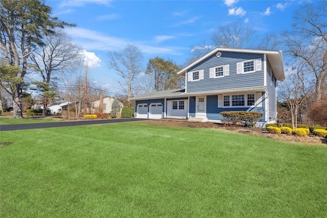 view of front of property with driveway, a front yard, and a garage