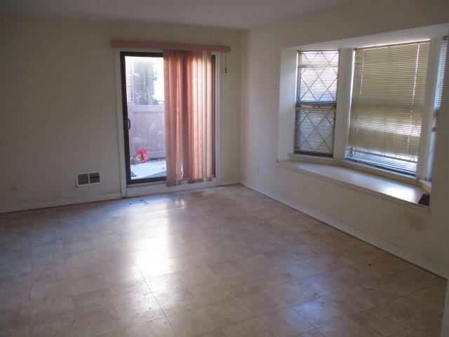 spare room with baseboards, visible vents, and tile patterned floors