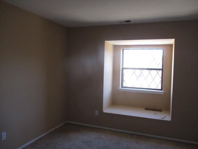 unfurnished room featuring carpet, baseboards, and visible vents