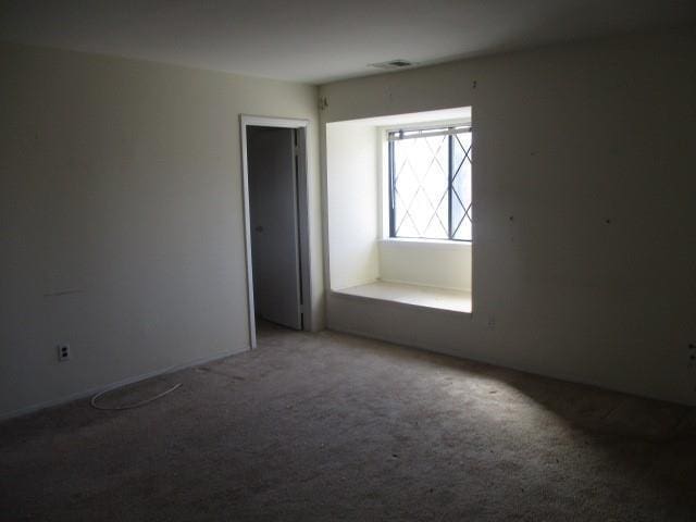 empty room featuring carpet and visible vents