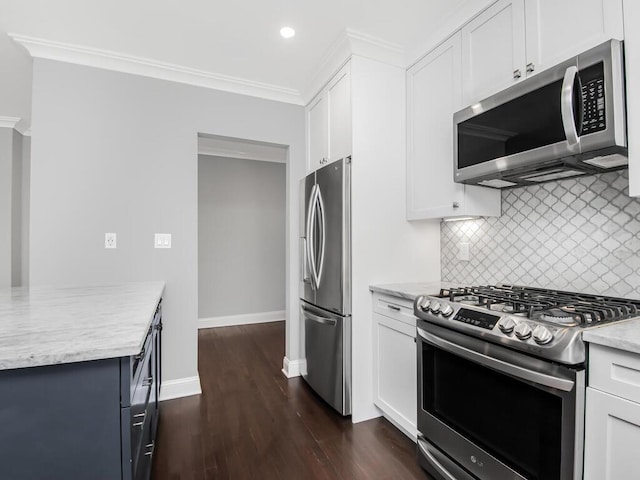 kitchen featuring tasteful backsplash, white cabinets, appliances with stainless steel finishes, dark wood-style flooring, and crown molding