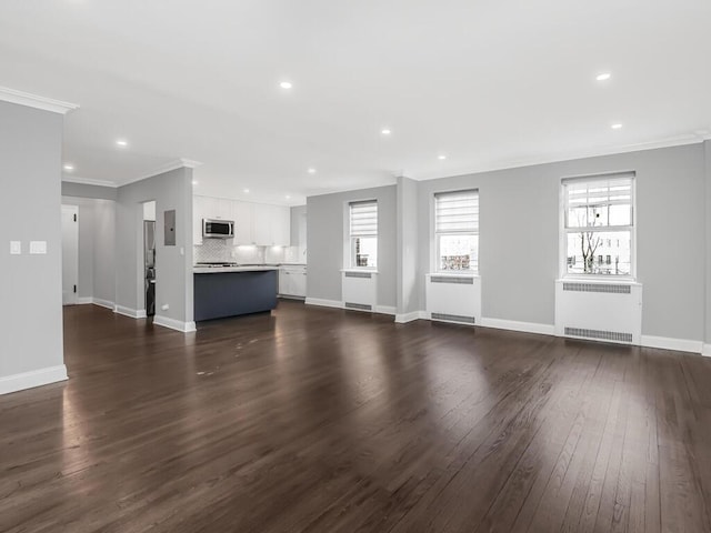 unfurnished living room featuring crown molding, dark wood-type flooring, baseboards, and radiator