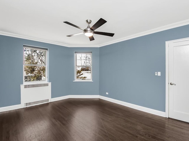 spare room featuring baseboards, ornamental molding, wood finished floors, and radiator