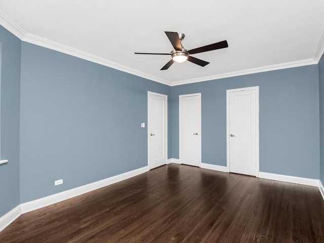 unfurnished bedroom featuring dark wood-type flooring, a ceiling fan, baseboards, multiple closets, and crown molding