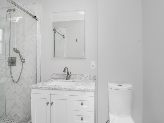 full bathroom featuring toilet, vanity, and a marble finish shower