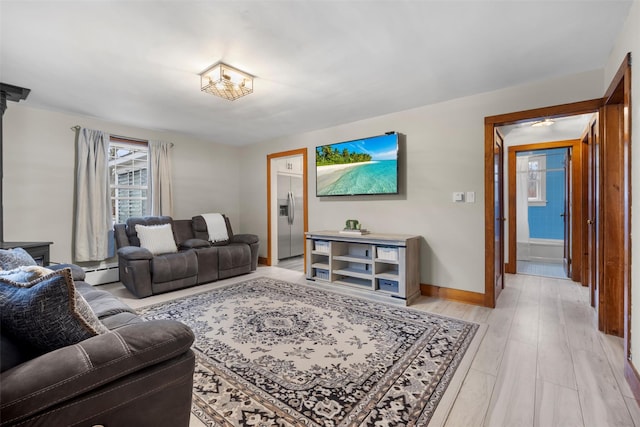 living area with light wood finished floors, baseboards, and baseboard heating