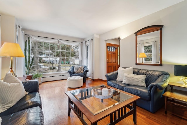 living area with wood-type flooring and baseboard heating