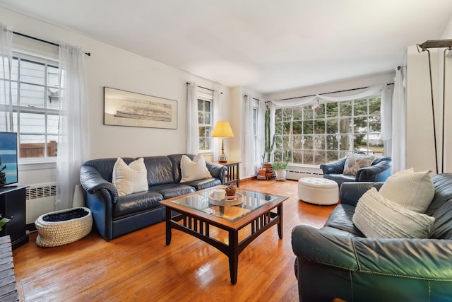 living area featuring radiator, light wood-type flooring, and a baseboard radiator