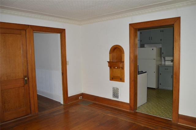 spare room with visible vents, a textured ceiling, wood finished floors, and ornamental molding