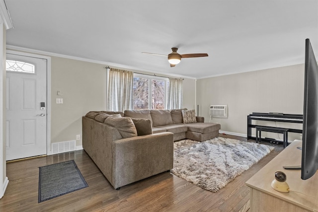 living room featuring a wall mounted air conditioner, visible vents, ornamental molding, a ceiling fan, and wood finished floors