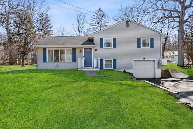 tri-level home with a garage, roof with shingles, a front yard, and aphalt driveway