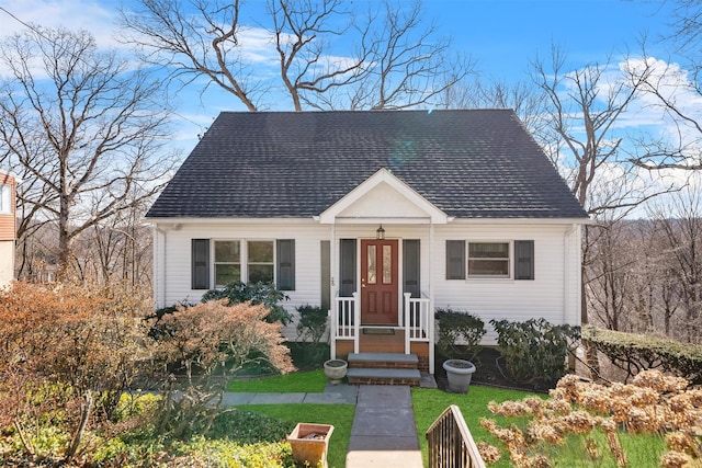 view of front of home with a front yard and roof with shingles