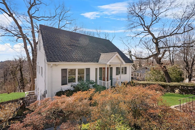 cape cod house featuring roof with shingles