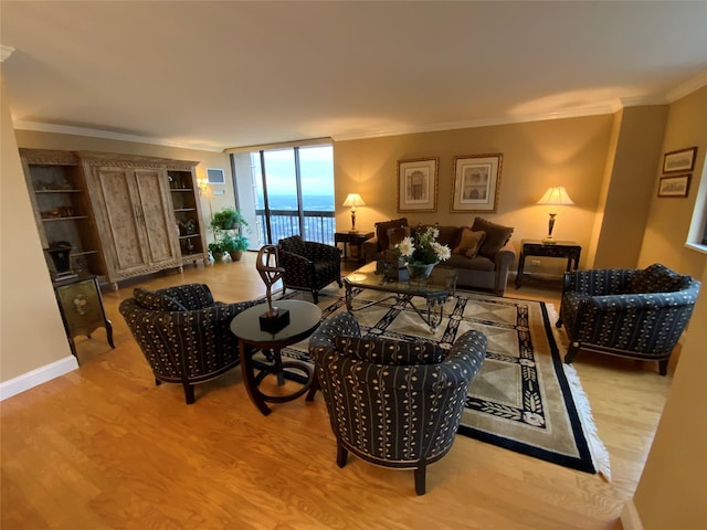 living area featuring baseboards, floor to ceiling windows, crown molding, and wood finished floors