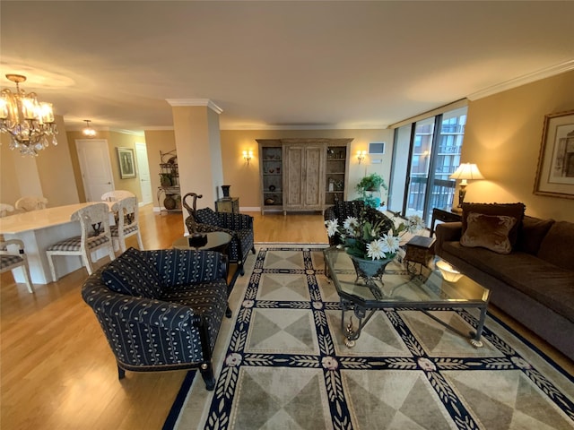 living area featuring ornamental molding, a notable chandelier, and light wood-style floors