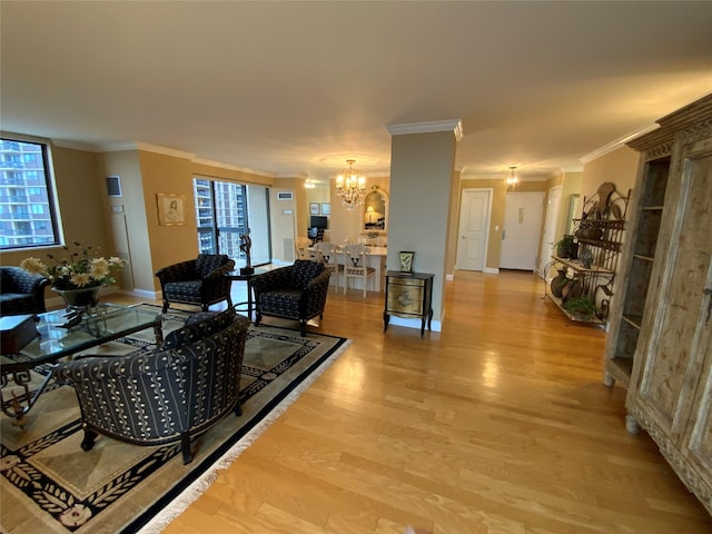 living room with ornamental molding, light wood finished floors, a wealth of natural light, and a notable chandelier