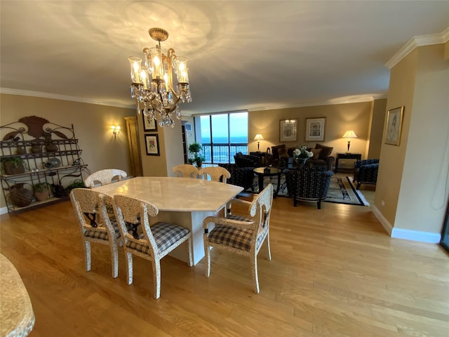 dining space featuring baseboards, light wood-style floors, and crown molding