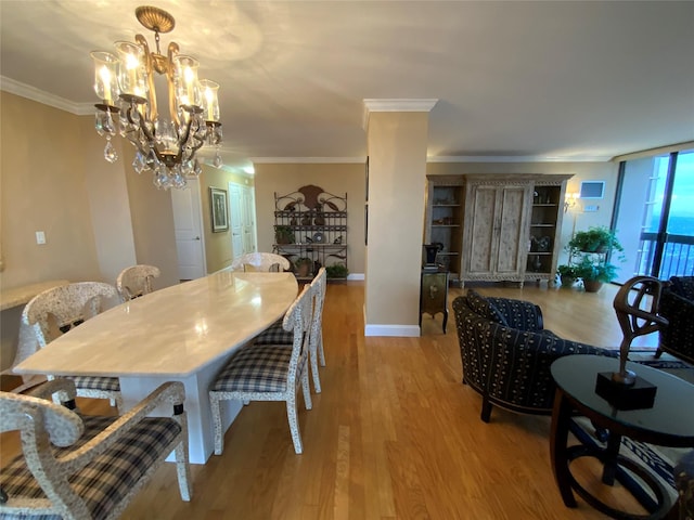 dining area featuring light wood-style flooring, baseboards, a chandelier, and crown molding