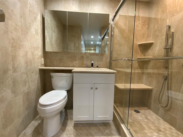 full bath featuring toilet, tile walls, a shower stall, and vanity