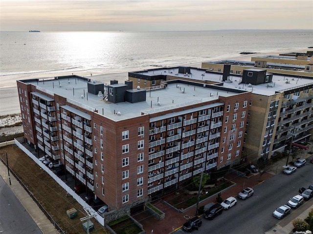 aerial view with a water view and a beach view