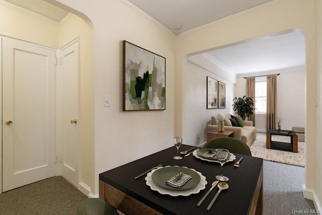 interior space featuring arched walkways, baseboards, crown molding, and carpet