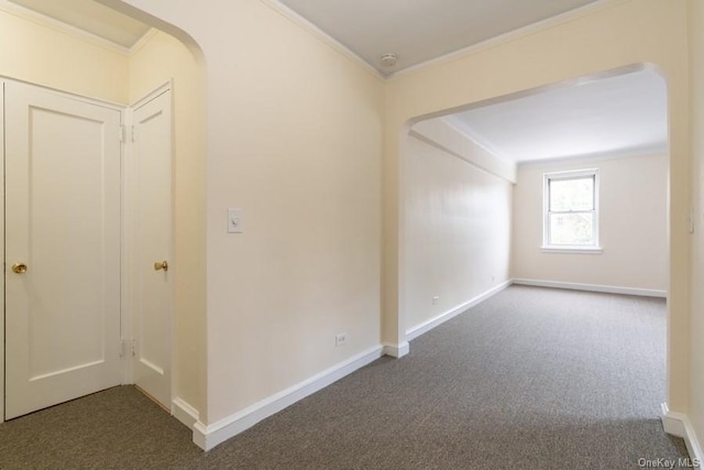 interior space featuring baseboards, arched walkways, and ornamental molding