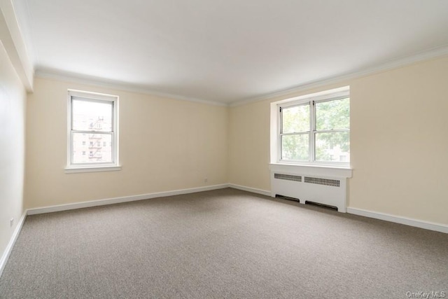 spare room featuring light carpet, radiator, baseboards, and ornamental molding