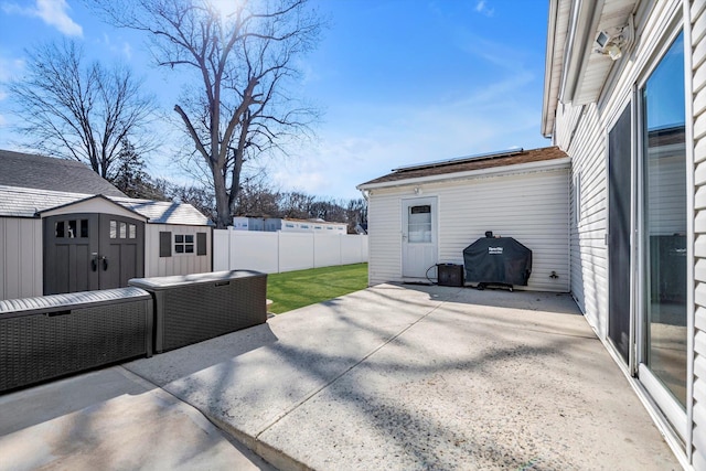 view of patio / terrace featuring a shed, a grill, fence, and an outdoor structure