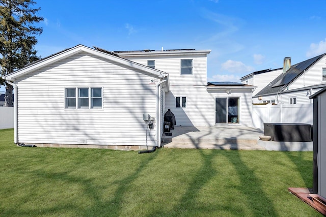 back of property featuring central AC, a lawn, a patio area, and fence