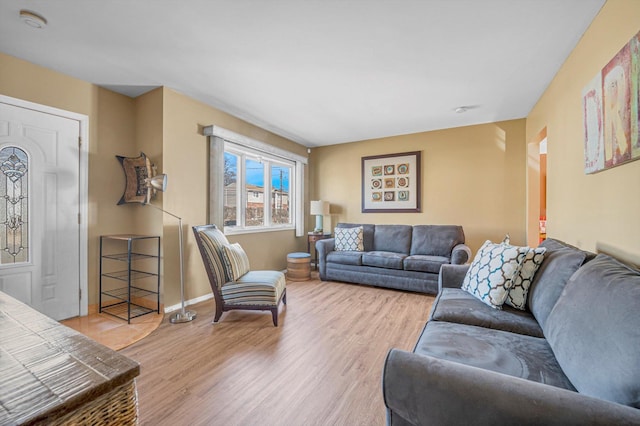 living room with baseboards, arched walkways, and wood finished floors