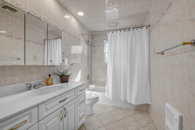 full bathroom featuring shower / bath combo, tile walls, vanity, and tile patterned floors