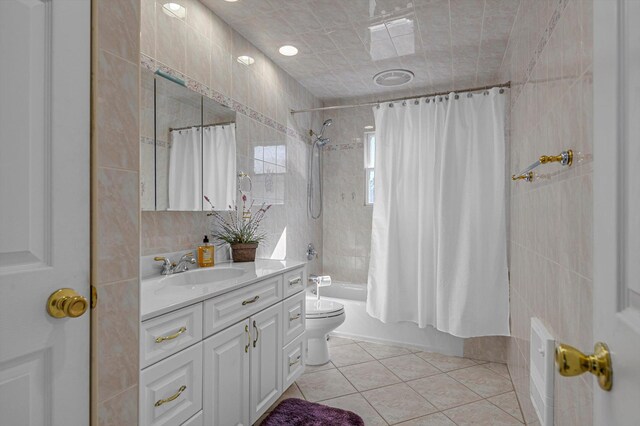 bathroom featuring shower / tub combo with curtain, tile walls, toilet, vanity, and tile patterned flooring