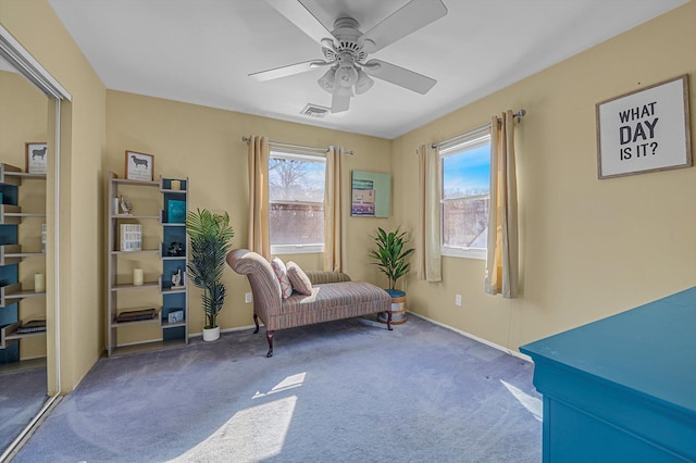 sitting room with carpet floors, ceiling fan, visible vents, and baseboards