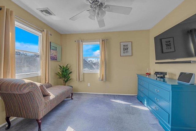 living area with carpet floors, visible vents, ceiling fan, and baseboards