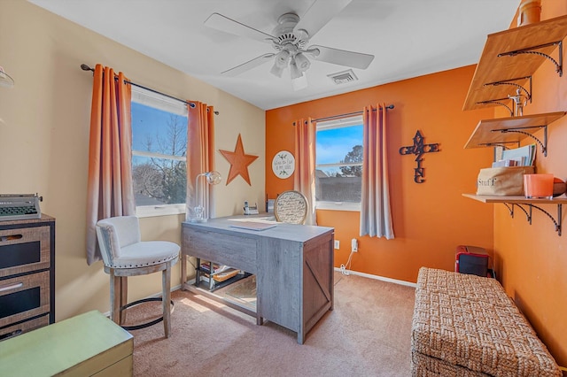 carpeted office space with a ceiling fan, visible vents, and baseboards