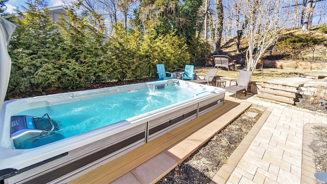 view of swimming pool with a patio area and an outdoor hot tub