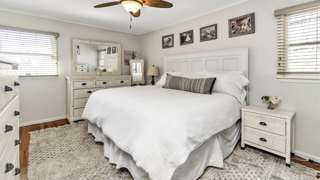 bedroom featuring a ceiling fan, baseboards, and wood finished floors