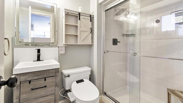 full bathroom featuring tasteful backsplash, a shower stall, toilet, and vanity