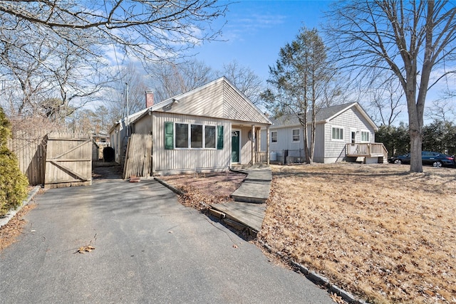 view of front of home featuring a gate, driveway, and a chimney