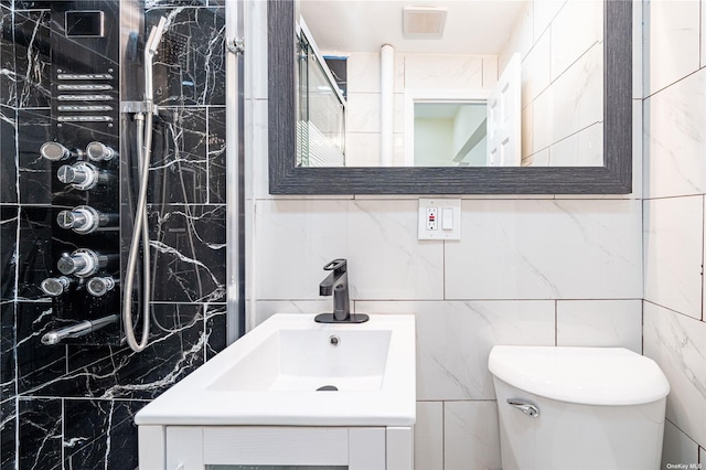 bathroom featuring tile walls, vanity, and toilet