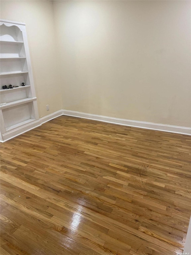 unfurnished room with wood finished floors and baseboards