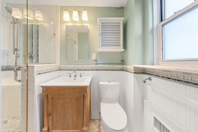 full bathroom with a wainscoted wall, a stall shower, vanity, and toilet