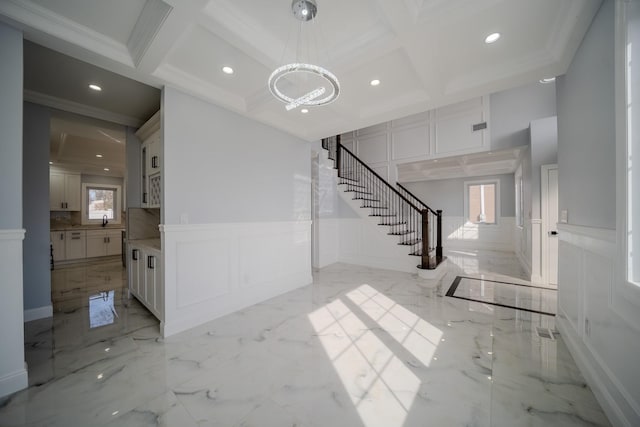 interior space featuring marble finish floor, stairway, a decorative wall, and coffered ceiling