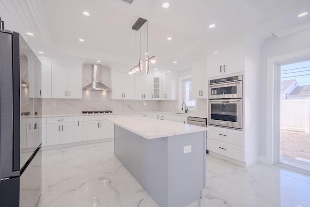 kitchen featuring appliances with stainless steel finishes, marble finish floor, a sink, and wall chimney range hood