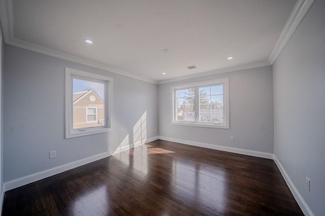 spare room featuring dark wood-style flooring, crown molding, and baseboards