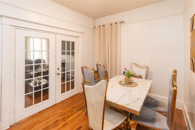 dining space with french doors and wood finished floors